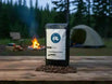 Coffee bag with 'Taylors Trail' branding on a wooden table with coffee beans, campfire, and tent in the background.